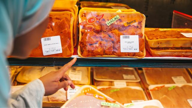 Woman looks at halal meat products at supermarket. Photo credit: iStock/LeoPatrizi.