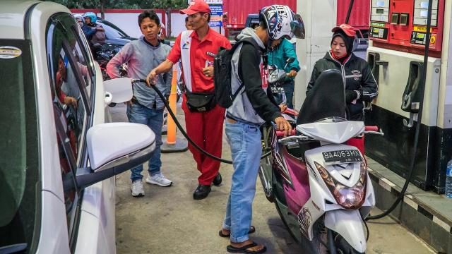 Motorists gassing up at a petrol station.